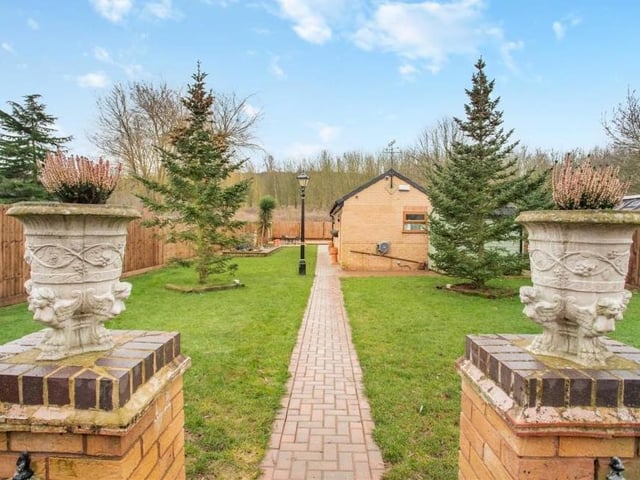 A pathway bisects the lawn in the attractive back garden at the Pleasley Vale property.