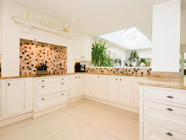 This is our first peek at the kitchen, which is thoroughly pristine. It is fitted with a range of base and wall-mounted units, granite work surfaces and a one-and-a-quarter bowl stainless steel sink with waste disposal system and mixer tap.