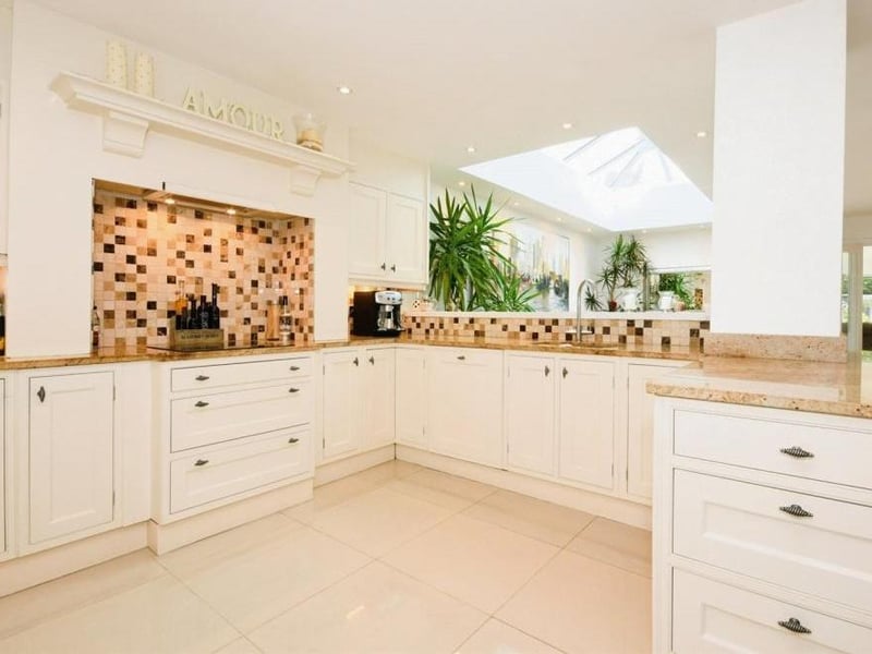 This is our first peek at the kitchen, which is thoroughly pristine. It is fitted with a range of base and wall-mounted units, granite work surfaces and a one-and-a-quarter bowl stainless steel sink with waste disposal system and mixer tap.