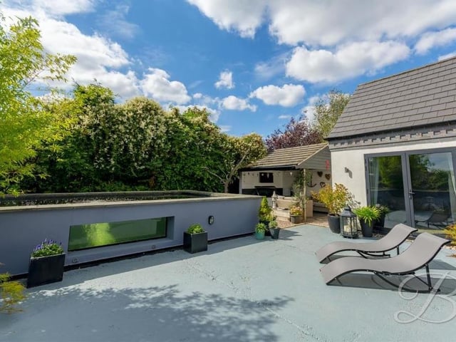 The enclosed garden at the back of the house features this seating area next to a large pond.