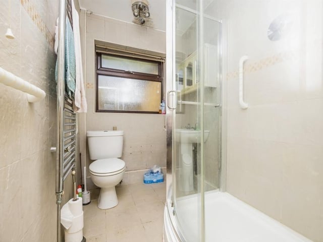 The shower room at the Thorpe Road bungalow is fitted with a shower cubicle, WC, wash hand basin, towel radiator, tiled flooring and extractor fan.