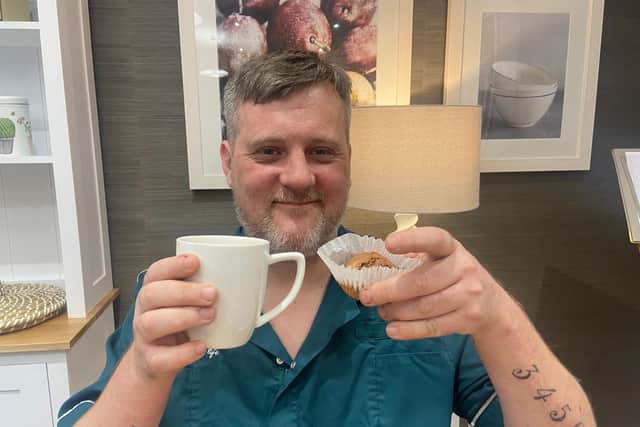 Carer Gareth Needham enjoying cake and a cuppa