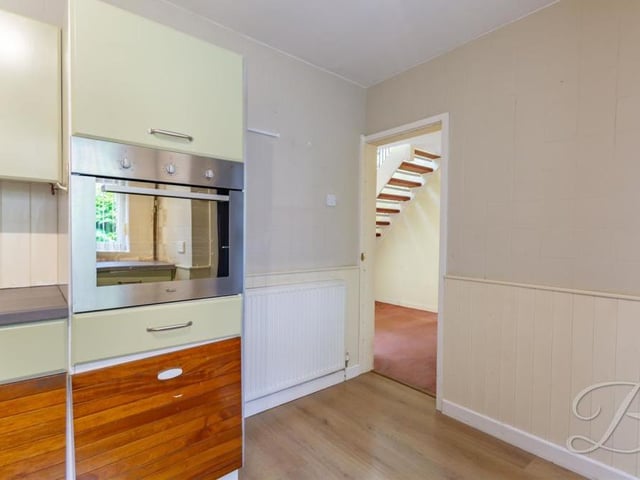A second shot of the kitchen, which features a fine range of matching units and cabinets, with a complementary worktop over. There's also an inset sink and drainer with mixer tap, integrated oven and gas hob.