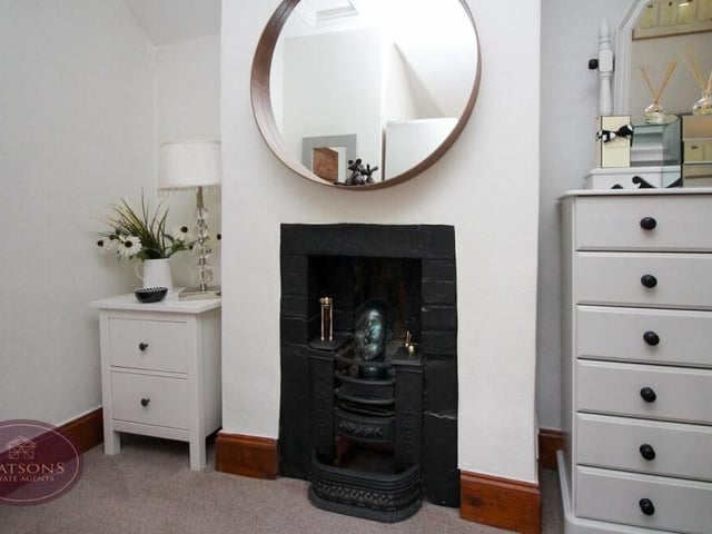 This feature fireplace adds an exquisite touch to the master bedroom at the 18th century Greens Lane cottage.