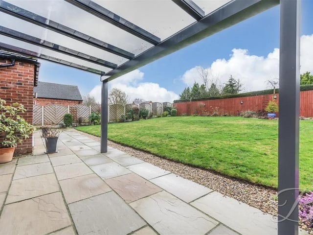 The well-maintained rear garden features a lawn, patio area, and a stunning pergola.