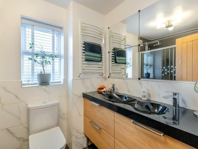 Most of the bedrooms on the first floor are served by this excellent family shower room. A modern three-piece suite with chrome fittings includes a large vanity unit with inset sink, two mixer taps and four storage drawers beneath, p,us a low-flush WC