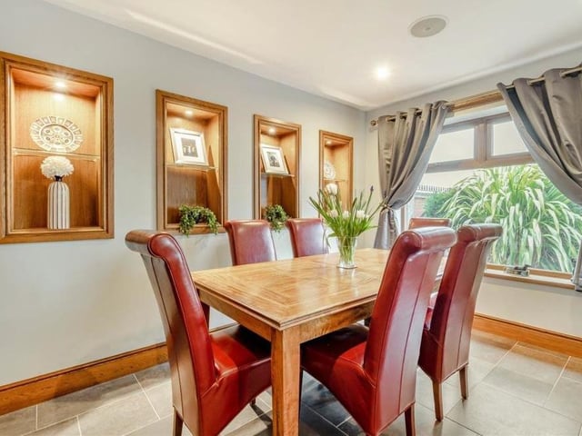 The open-plan sitting room/dining room features several framed wall niches with inset spotlights.