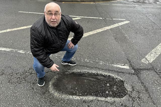 Coun Andy Meakin by the huge pothole on Urban Road in Kirkby which he says is the worst in the county. Photo: Submitted