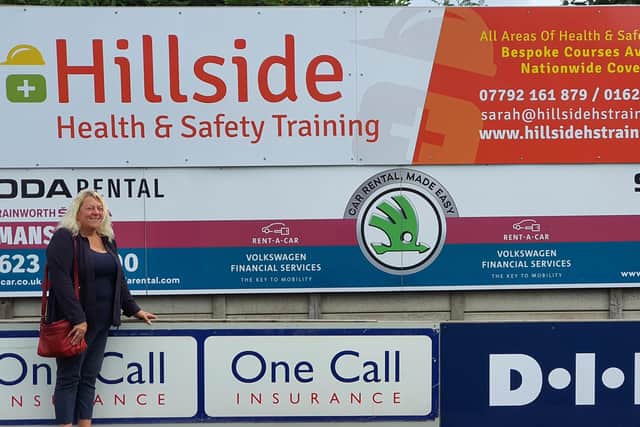 Sarah with her advertising board at the ground.