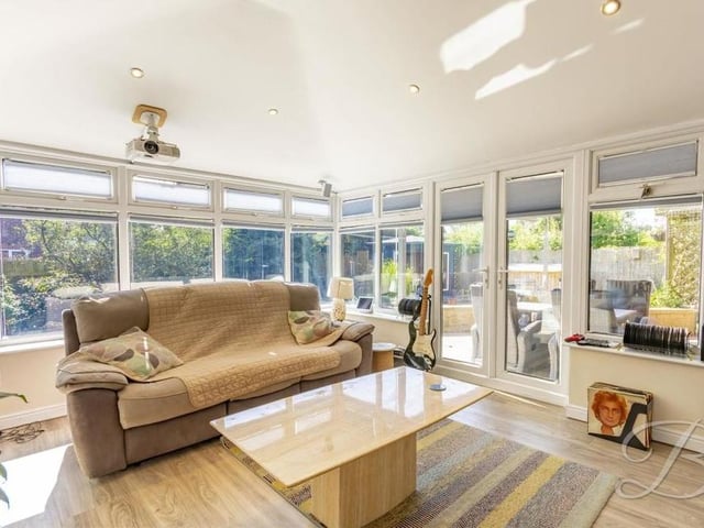 From the living room, it's just a couple of steps into this conservatory, which makes for a spectacular sight. Windows give fine views of the garden, and there is plenty of space for furniture. The doors lead outside.