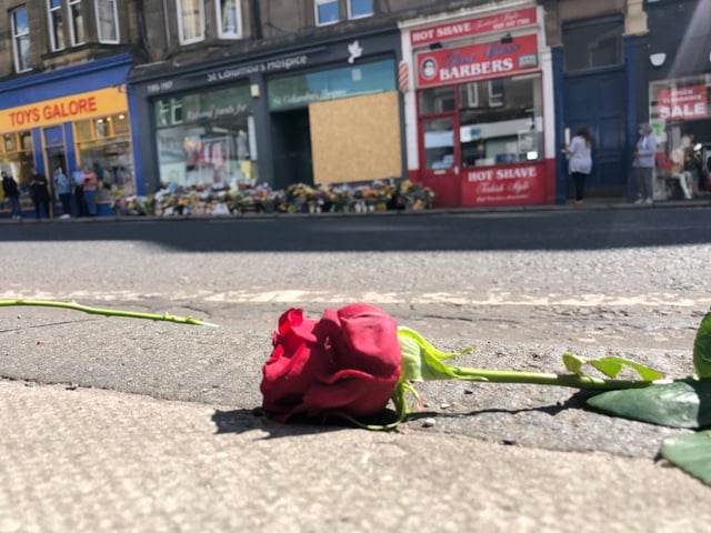 Red roses were laid along the pavement of Morningside Road in tribute to the toddler