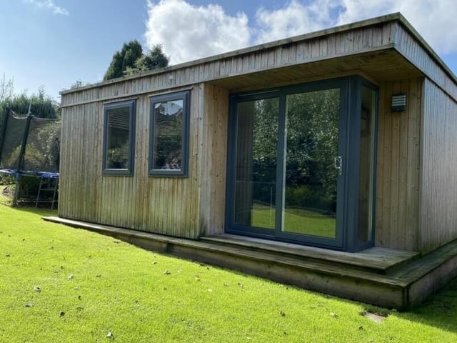 And finally, as we step outside, here's what you've been waiting for -- that log cabin in the garden. A modern structure, it is equipped with fitted units and a fridge, and it could be converted into anything you like -- from a games room or summer house to an office or gym. And if it snows at Christmas, well you have your ready-made festive log cabin!