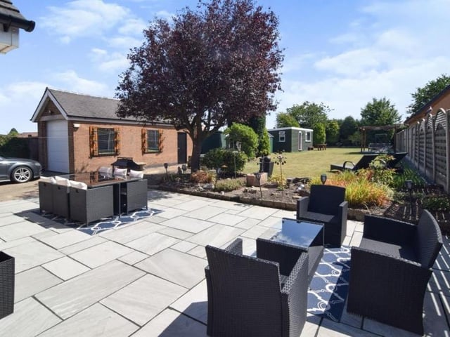 Lazy days in the sun are guaranteed in this lovely patio area at the back of the bungalow. Spot the sturdy garage in the background too.