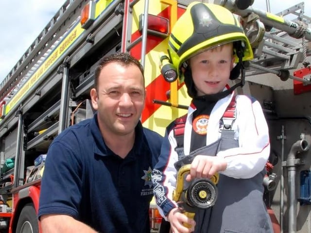 Pupil Braydon Warren (6), became a firefighter for the day at Sutton's St Mary Magdalene Primary School summer fair. Braydon is pictured with Ashfield Red Watch firefighter, Peter White.