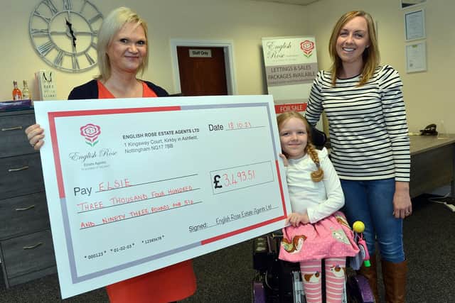 English Rose estate agents at Kirkby present a cheque to seven-year-old  Elsie Novell who needs a new wheelchair. Seen here are English Rose company director Julie Cotterill presenting the cheque to Elsie Novell and her mum Charlotte Novell.