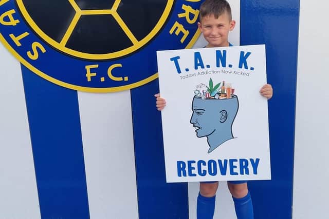 Adam's nephew is holding the charity's logo.