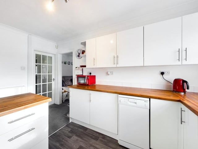 Matching wall and base units, drawers and cupboards offer an abundance of storage space in the squeaky-clean kitchen.