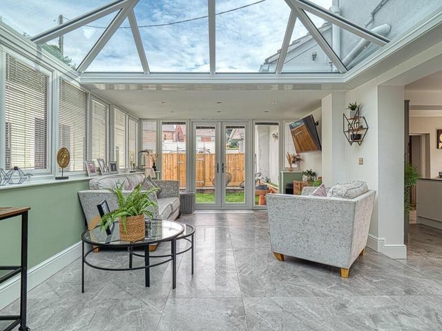 The kitchen also opens into this conservatory which, with its glass roof, induces the wow factor. The underfloor heating continues here, and French doors open on to a rear courtyard.