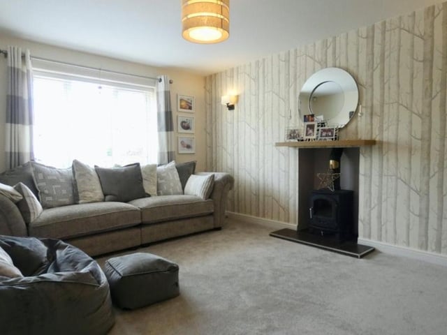 On the other side of the kitchen sits this spacious living room. Warm and bright, the space has its characterful features.