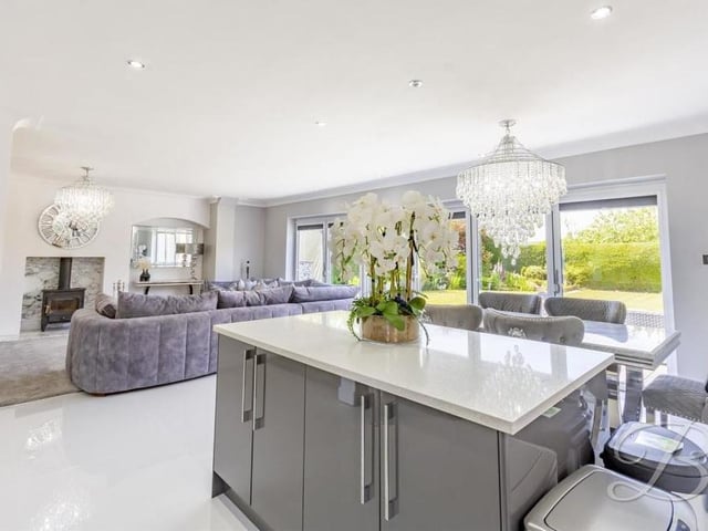 A lovely shot of the kitchen island, with its additional cupboard space, overlooking the rest of the open-plan living area, with its array of windows and doors letting in a flood of natural light.