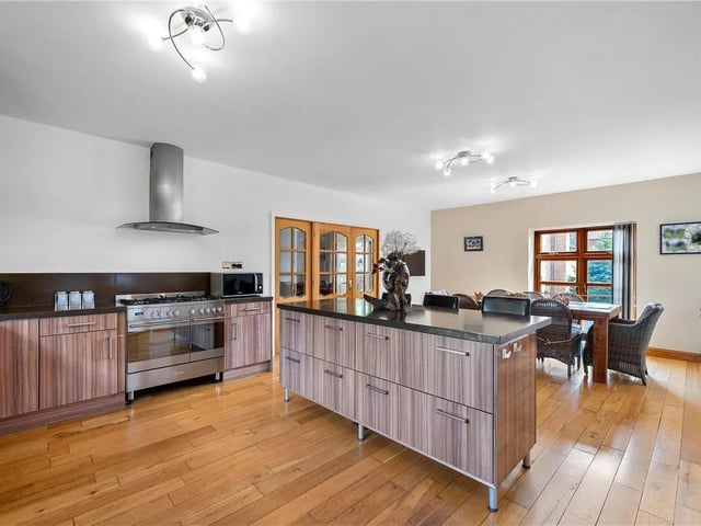 The stunning kitchen features a range cooker with double oven, integrated dish washer, wooden flooring with zoned under floor heating and a door leading to the utility room.