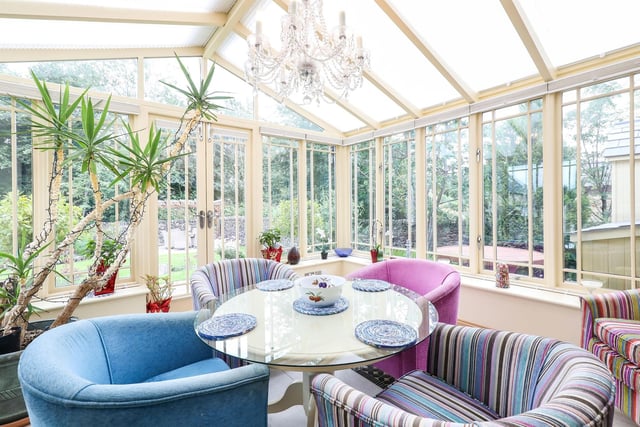 The conservatory, with double-glazed French doors and a tiled floor, has views over the rear garden.