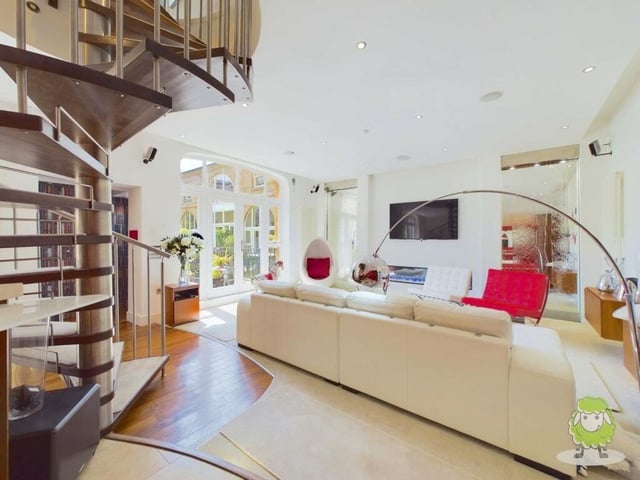 Moving on to the living area within the open-plan space. It features internal waterfalls and large windows overlooking the exterior courtyard.