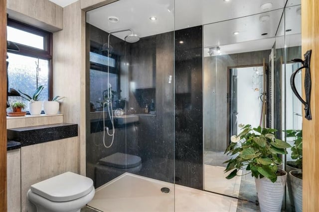 The ground floor of the terraced cottage includes this modern shower room. As well as a double walk-in shower, it features a vanity unit, low-flush WC, built-in cupboard, heated towel-rail and porcelain tiled floor.