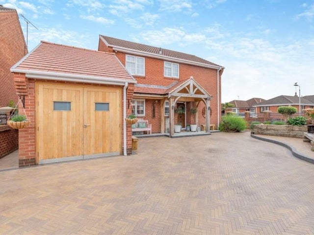 The final photo of our gallery shows how the house sits on a corner plot, behind a boundary of walls and railings, and the driveway leads to an integral single garage, equipped with power and light.