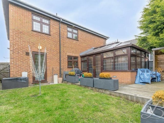 This shot captures the back of the property, complete with conservatory jutting out and well-maintained lawn.