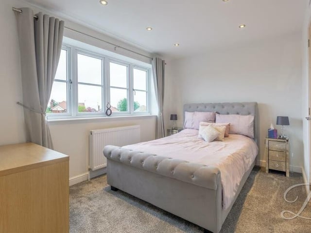 Another stylish bedroom, complete with fitted carpets, downlights, fitted wardrobes and storage space. It overlooks the back of the house.
