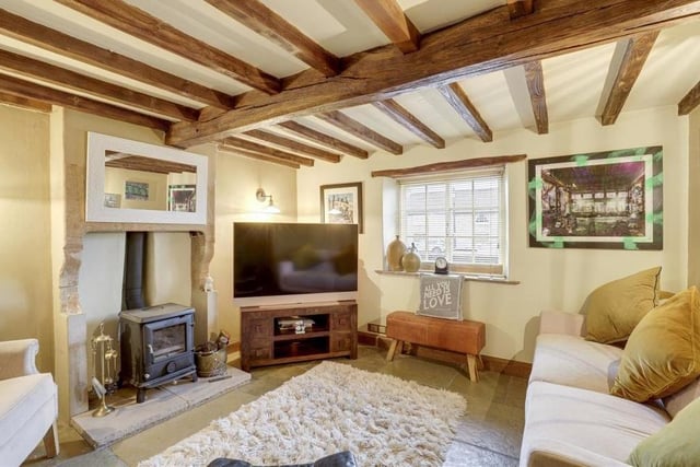 How about this for a quintessentially rustic English cottage living room? Its exposed beams and chimney breast alcove with Aga wood-burning stove give it oodles of character.