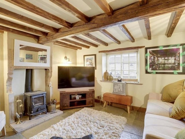 How about this for a quintessentially rustic English cottage living room? Its exposed beams and chimney breast alcove with Aga wood-burning stove give it oodles of character.