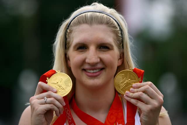 Becky Adlington of Great Britain holds up her Beijing golds.