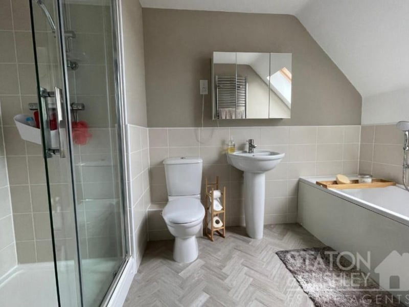 The en suite bathroom to the master bedroom at the £450,000 house is a sparkling sight. It features a panelled bath with mixer tap and shower attachment, a shower cubicle with mains-fed shower, a pedestal sink with mixer tap, a low-level WC, partly tiled walls and a heated towel-rail.