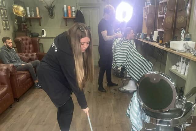 Eleele Evans carrying out her work placement at Moon's Barber Shop in Mansfield.
