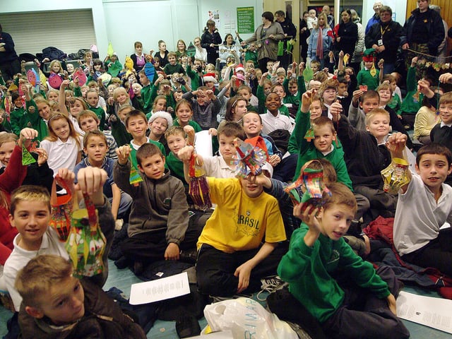 Children at Oaktree Lane Primary School, Mansfield, held a tree blessing ceremony in the school hall because it was too wet to do it among the trees. The children are holding decorations they have made for the trees. 2007.