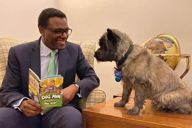 Broxtowe MP Darren Henry reading with his dog Poppy.