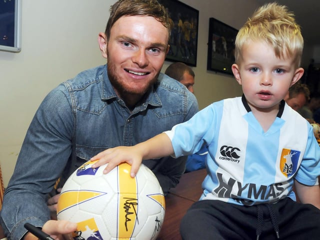 Kori Byrne gets his ball signed by Ritchie Sutton at the open day.