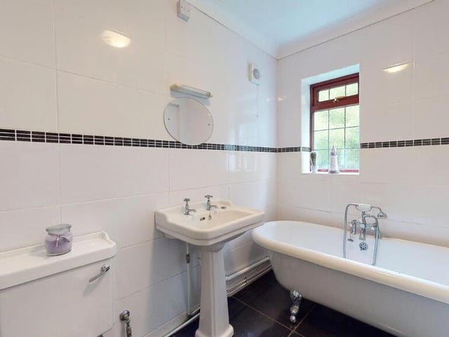 The main bedroom is served by this well-appointed en suite bathroom, which includes a rolled-edge claw-foot bath with shower attachment. You will also find a deep-glazed pedestal wash hand basin, a low-flush WC, a stainless steel heated towel-rail, a porcelain tiled floor and fully tiled walls.