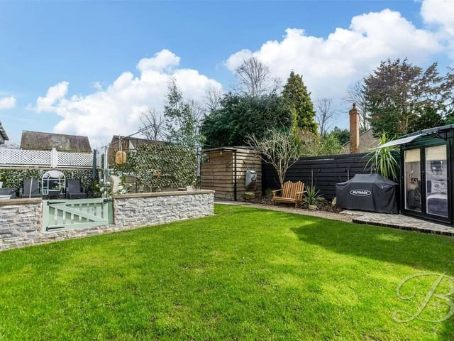 At the rear, the garden is a true sanctuary, beautifully landscaped for year-round enjoyment. It features a well-maintained lawn, along with a dedicated patio seating area, ideal for relaxing with outdoor furniture and access by a bridge over a lovely pond. Additionally, the garden is home to a charming summer house, currently used by the owners as a cosy second living space.