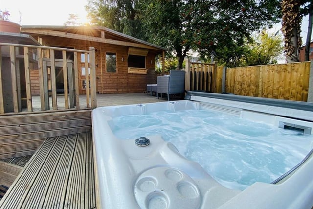 The hot tub, decked terrace and garden house.