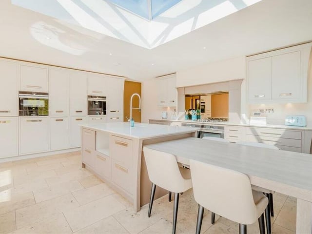 At the heart of the kitchen is a large island centrepiece and a lower-level, fitted breakfast table with base units, deep pan-drawers and extensive quartz worktops. There is also an inset ceramic sink with spray mixer tap and double, built-in drainer to the worktop on each side.