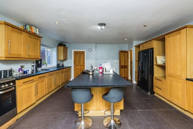 Let's move on now to the spacious and stylish kitchen, with its island and sink units that incorporate storage and seating. Other assets are gas hobs, space for an American-style fridge freezer, tiled flooring and French doors leading to the garden. Not far away is a utility room with connections for other appliances.