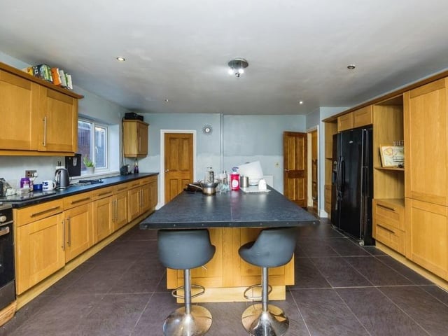 Let's move on now to the spacious and stylish kitchen, with its island and sink units that incorporate storage and seating. Other assets are gas hobs, space for an American-style fridge freezer, tiled flooring and French doors leading to the garden. Not far away is a utility room with connections for other appliances.