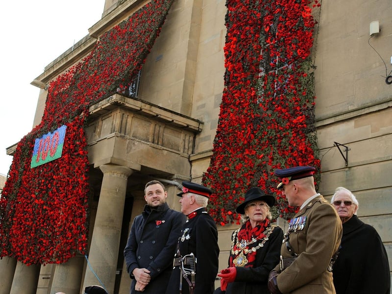 Mansfield's Executive Mayor, Coun. Kate Allsop joins other dignitaries in front of the old Town Hall, festooned in 16,000 hand knitted poppies before taking the salute.