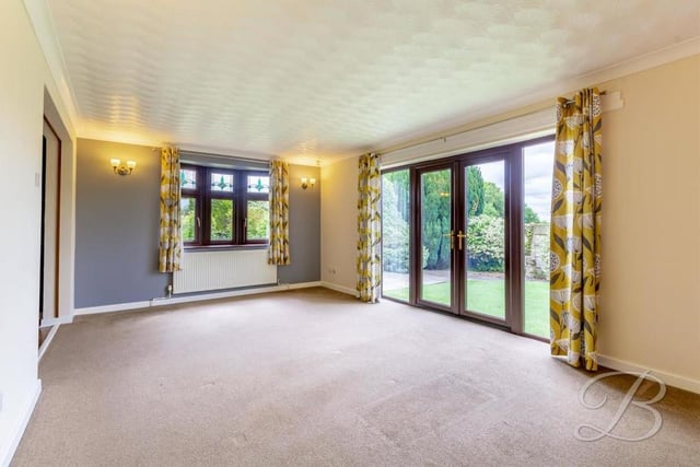 Let's start our tour of the Kirkby bungalow in the bright and cheerful lounge or living room. The floor is carpeted and the double doors lead out to the front garden.