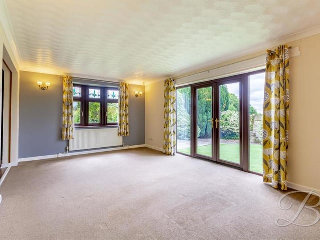 Let's start our tour of the Kirkby bungalow in the bright and cheerful lounge or living room. The floor is carpeted and the double doors lead out to the front garden.
