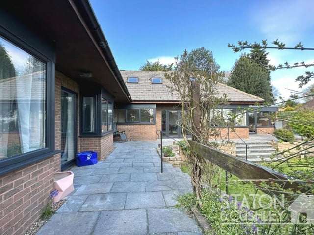A photo that shows how doors from the property lead on to a terrific terrace that oversees the rear garden.