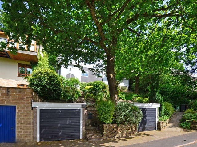 Outside, there are two single garages, one with an electric door.